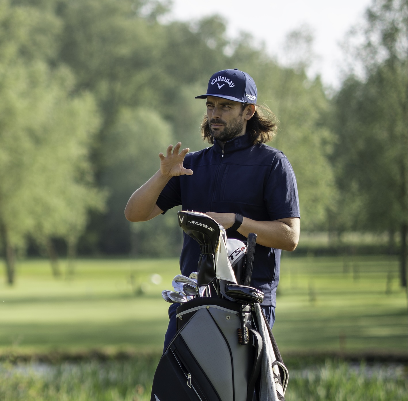 Andrew coaching beside a golf bag
